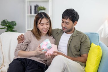 Çift gülüşü ve mutlu açık hediye, sürpriz, kucaklaşma, sıcak kucaklaşma, genç aşk, evli çift, sıcak aile. Karı koca birbirlerini çok seviyorlar. Önemli günlerde, kutlama yapıyorlar.