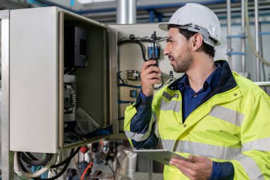 Mechanic or maintenance or electrical engineer checking main electrical control systems industrial plant. Utility fore man daily check power systems in process. Main Distribution Board, Switchboards