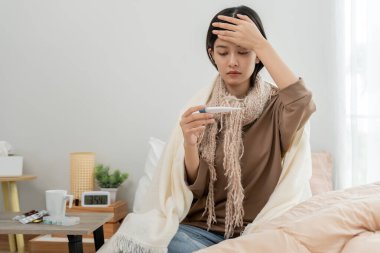 sick woman with a headache sitting under blanket, female sneezing and runny nose with seasonal influenza, allergic, high fever and influenza, resting, virus, coronavirus, feel illness, respiratory