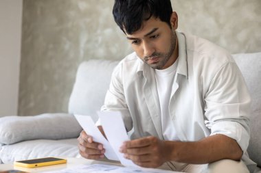 Yüklü faturaları ve faturaları olan stresli ve baş ağrısı çeken Asyalı bir adamın harcamaları ve kredi kartı borçlarını ödeyecek parası yok. kıtlık, mali sorunlar, mortgage, kredi, iflas, iflas, yoksul, boş cüzdan
