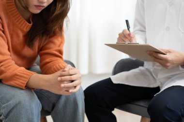 Akıl sağlığı sorunları olan bir kadın danışmanlık yapıyor. Psikiyatrist tedavi için hastanın durumunu kaydediyor. teşvik, sevgi ve aile sorunu, bipolar, depresyon hastası, intiharı koru