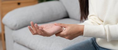 Karpal tünel sendromu ya da bilek eklemi iltihabı olan Asyalı genç bir kadın. Ofis sendromundan dolayı el kası iltihabı.