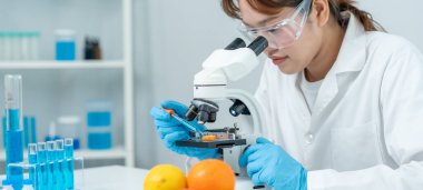 Scientist check chemical food residues in laboratory. Control experts inspect quality of fruits, vegetables. lab, hazards, ROHs, find prohibited substances, contaminate, Microscope, Microbiologist