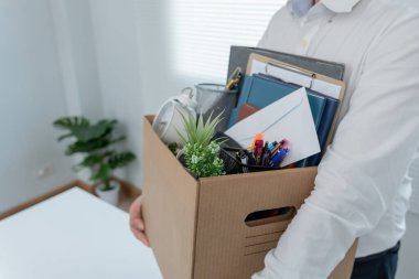 Stresli iş adamları şirketten istifa edecek. İçinde kişisel eşyalar olan kahverengi bir karton kutuyu kaldırmak. İstifa, iş yerleştirme ve boşluklar kavramı.
