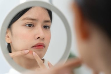 Young woman are worried about faces Dermatology and allergic to steroids in cosmetics. sensitive skin, red face from sunburn, acne, allergic to chemicals, rash on face. skin problems and beauty