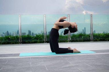 Slim woman practicing yoga on balcony. at condo or home. Asian woman doing exercises in morning. balance, meditation, relaxation, calm, good health, happy, relax, healthy lifestyle, diet, slim