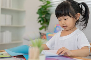 Mutlu Asyalı çocuklar evde kitap okuyarak rahatlar. Kızım ve bir hikaye okuyordum. öğrenme, çocuk bakımı, gülme, eğitim, hikaye anlatma, uygulama, hayal etme, bağımlılık cep telefonunu azaltma