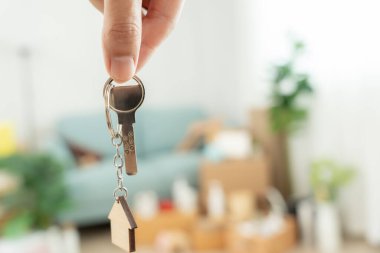 Moving house, relocation. Man hold key house keychain in new apartment. move in new home. Buy or rent real estate. flat tenancy, leasehold property, new landlord, investment, dwelling, loan, mortgage.