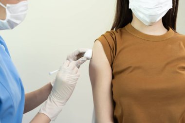 Kadın salgını önlemek için aşı oluyor. Tıp merkezindeki bir hemşire ya da doktordan bir doz bağışıklık aşısı al. Temel aşı, alternatif aşı, risk grubu aşısı.