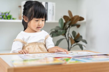 Mutlu Asyalı çocuklar evde kitap okuyarak rahatlar. Kızım ve bir hikaye okuyordum. öğrenme, çocuk bakımı, gülme, eğitim, hikaye anlatma, uygulama, hayal etme, bağımlılık cep telefonunu azaltma