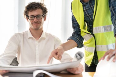 Mühendisler inşaat planlarını gözden geçirir. Sivil projeye başlamadan önce müteahhit teftişi çizimi. proje planlaması, danışmanlık, mimari.