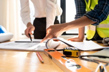 Mühendisler ve sahipleri inşaat planlarını gözden geçirip kontrol etmeyi tartıştılar. Sivil projeye başlamadan önce müteahhit teftişi çizimi. proje planlaması, danışmanlık, mimari.