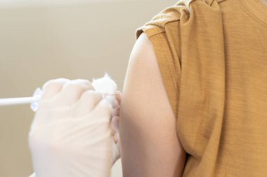 Kadın salgını önlemek için aşı oluyor. Tıp merkezindeki bir hemşire ya da doktordan bir doz bağışıklık aşısı al. Temel aşı, alternatif aşı, risk grubu aşısı.