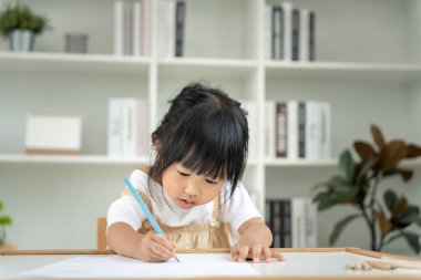 Mutlu Asya çocukları kağıt üzerinde resim yapmayı öğreniyor. Etkinlik, gelişim, IQ, EQ, meditasyon, beyin, kas, temel beceriler, ailenin birlikte zaman geçirmesi. Holida.