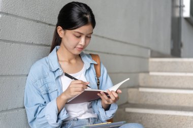 Güzel Asyalı kız öğrenci. Gülümseyen kız mutlu çalışmalar. Üniversite kampüsünde kitap okudum. Uluslararası Asya Üniversitesi 'nde genç bir bayan. Eğitim, öğrenim, okul, öğrenme, sınav, eğitime devam