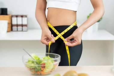 Diyet ve diyet. Güzel, ince kadın vücut ölçüsü. Spor elbiseli bir kadın sağlıklı yaşam için kilo verme hedefine, zayıflığa, ince belliye, beslenme uzmanına ulaşır.