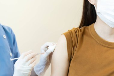 Kadın salgını önlemek için aşı oluyor. Tıp merkezindeki bir hemşire ya da doktordan bir doz bağışıklık aşısı al. Temel aşı, alternatif aşı, risk grubu aşısı.