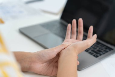 Karpal tünel sendromu ya da bilek eklemi iltihabı olan genç bir kadın. Ofis sendromundan dolayı el kası iltihabı.