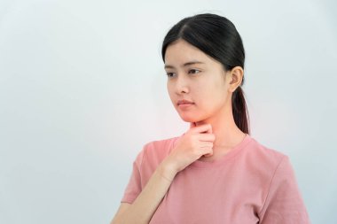 Asyalı kadın boğazı ağrıdığı için boynuna takıldı. Dişi bademcik iltihabı iltihaba neden olur. Su alarak, antibiyotik alarak, doktora, virüse, korona virüsüne, grip virüsüne danışarak,