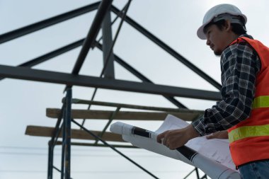 Müfettiş ya da mühendis mavi baskı kullanarak inşaat ve kalite güvencesini denetliyor. Mühendis, mimar ya da irtibat kurucu ev sahibine teslim etmeden önce evi inşa etmek için çalışır.