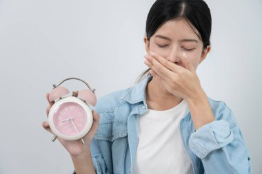 Asya 'lı genç bir kadın geç saatte uyuyor, bayan işe geç geliyor ya da ders çalışıyor, uyuyakalıyor, sabahları uyanıyor, endişeleniyor, uykulu, geç kalmış, geç kalmış.