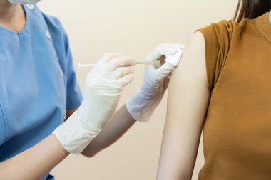 Kadın salgını önlemek için aşı oluyor. Tıp merkezindeki bir hemşire ya da doktordan bir doz bağışıklık aşısı al. Temel aşı, alternatif aşı, risk grubu aşısı.