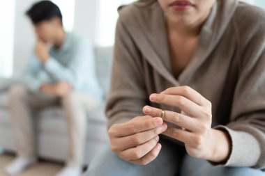 Boşanma. Karım evlilik yüzüğünü çıkarıp boşanma formunu imzaladı. Evlilikten sonra çaresiz ve hayal kırıklığına uğramış çiftler. Eş üzgün, üzgün ve kavgalar yüzünden hayal kırıklığına uğramış. güvensizlik, aşk sorunları