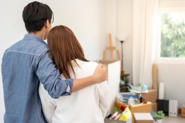 Taşınmak, taşınmak. Çift yeni evdeki mobilyalar için uzay odasına baktı, odanın içinde kişisel eşyalar içeren bir karton kutu vardı. yeni daireye ya da daireye taşın.