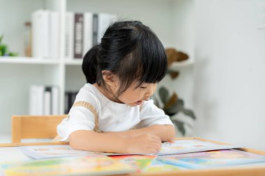 Mutlu Asyalı çocuklar evde kitap okuyarak rahatlar. Kızım ve bir hikaye okuyordum. öğrenme, çocuk bakımı, gülme, eğitim, hikaye anlatma, uygulama, hayal etme, bağımlılık cep telefonunu azaltma