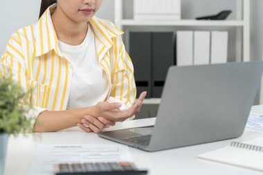 Karpal tünel sendromu ya da bilek eklemi iltihabı olan Asyalı genç bir kadın. Ofis sendromundan dolayı el kası iltihabı.