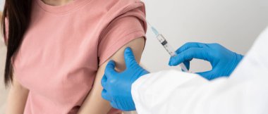 Kadın salgını önlemek için aşı oluyor. Tıp merkezindeki bir hemşire ya da doktordan bir doz bağışıklık aşısı al. Temel aşı, alternatif aşı, risk grubu aşısı.