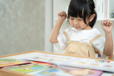 Mutlu Asyalı çocuklar rahatlayın ayı bebek için masal kitabı okuyun. Kızım ve bir hikaye okuyordum. öğrenim geliştirme, çocuk bakımı, eğitim, hikaye anlatma, uygulama, hayal etme, bağımlılık cep telefonunu azaltma