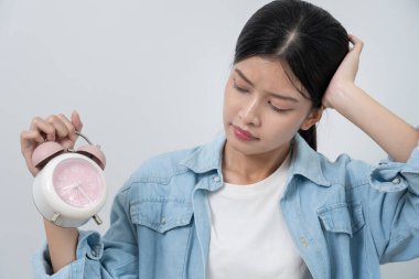 Shocked Asia young woman looking at clock alarm, lady is late appointment or work or class study, overslept, difficulty get up in mornings, time worried, not on time, sleepy, over due, Hurry up time
