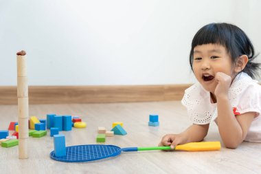 Mutlu Asya çocukları oyuncak bloklarıyla oynayıp öğreniyor. Aile evde mutlu ve heyecanlı. Kızın zaman, etkinlik, gelişme, IQ, EQ, meditasyon, beyin, kaslar, temel beceriler.