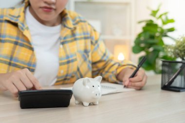 Para biriktir. İş kadını kumbaraya tasarruf için para koyuyor. wealth, Finance, business, invest, Emeklilik, future, muhasebe, plan life, economize, bankacılık, family, health.