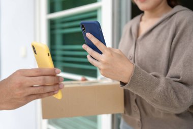 Happy smiling woman receives boxes parcel from courier in front house. Delivery man send deliver express. online shopping, paper containers, takeaway, postman, delivery service, packages