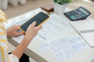 woman use phone scan barcode or QR codes to pay credit card bill after receiving document invoice. payment, receive, paying electricity, digital payments, technology, scanning, financial transactions