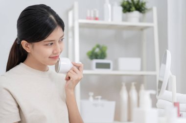 Güzel Asyalı kadınlar gözeneklerini sıkmak için aletler kullanır. Sağlıklı yüzler. Yüz bakımı ve tedavisi. Deri reklamı. Yüz kremi, kırışıklık önleyici, bebek yüzü, beyazlatma, nemlendirici, gözenek sıkılaştırıcı serum.