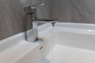 Su tasarrufu. Adam çevreyi korumak için tuvaletteki suyu kapatıp duruyor. Yeşillenen gezegen, küresel ısınmayı azalt Dünya 'yı, yaşamı, geleceği, risk enerjisini, krizi, su gününü kurtar