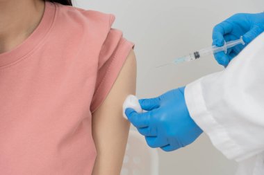 Kadın salgını önlemek için aşı oluyor. Tıp merkezindeki bir hemşire ya da doktordan bir doz bağışıklık aşısı al. Temel aşı, alternatif aşı, risk grubu aşısı.