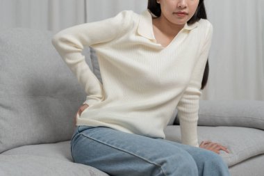 Kadın kendini tutuyor ve dayanılmaz ağrılar çekiyor. Sağlık ve sorunlar, kronik sırt ağrısı, ofis sendromu, skolyoz, bel fıtığı, kas iltihabı.