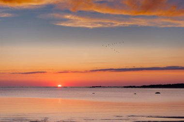 Güneş ufukta kaybolmak üzere ve gökyüzü kırmızıya dönüyor..