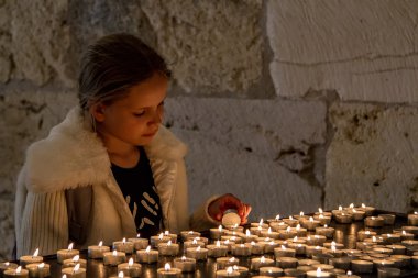 Teenage girl lights the candles clipart