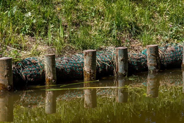 Montones de madera a lo largo del canal — Foto de Stock