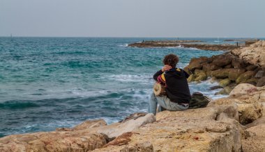 Genç adam Akdeniz Tel Aviv'de bakarak