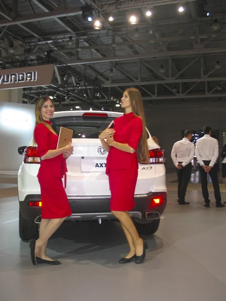 Girl model posing near the car at the car show. Moscow International Auto Show 2016. — Stock Photo, Image