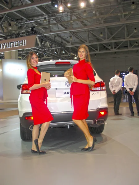 Girl model posing near the car at the car show. Moscow International Auto Show 2016. — Stock Photo, Image