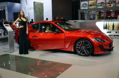 Maserati ekibinden genç bir kadın. Car yakınındaki uzun siyah elbise. Gran Turismo. Kırmızı araba. Moskova Uluslararası Otomobil Salon lüks Premium
