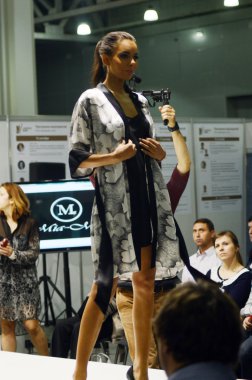 Intercharm XXI International Perfumery and Cosmetics Exhibition Lingrie Expo Traffic Young beautiful brunette in a dressing gown with flowers and black lingerie Look Flash