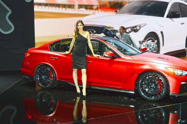 Moscow International Automobile Salon Young Brunette Mulheres da Infiniti Team em vestido preto perto de carro vermelho — Fotografia de Stock